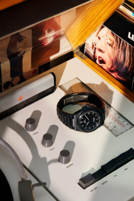 Photograph by Roderick Aichinger for Esquire Germany magazine, fall 2025 issue. This image features the IWC Ingenieur Automatic 42 Black Ceramic (ref. IW338903), placed on a vintage stereo console with visible vinyl records and audio controls. The composition showcases the modern, monochrome IWC Ingenieur in a nostalgic, music-inspired setting, emphasizing its ceramic case and integrated bracelet design.