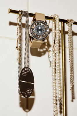 Photograph by Roderick Aichinger for Esquire Germany, fall 2025 issue. The image features the Louis Vuitton Tambour Convergence with a silver dial and beige calf leather strap, displayed amid pearl and metal jewelry on a bathroom fixture. The composition highlights the modern, architectural lines and luxurious materials of the latest Louis Vuitton Tambour Convergence model.