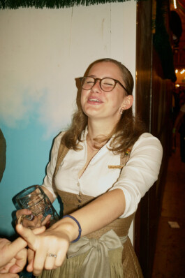 A woman dressed in traditional Bavarian attire, wearing a name tag that reads